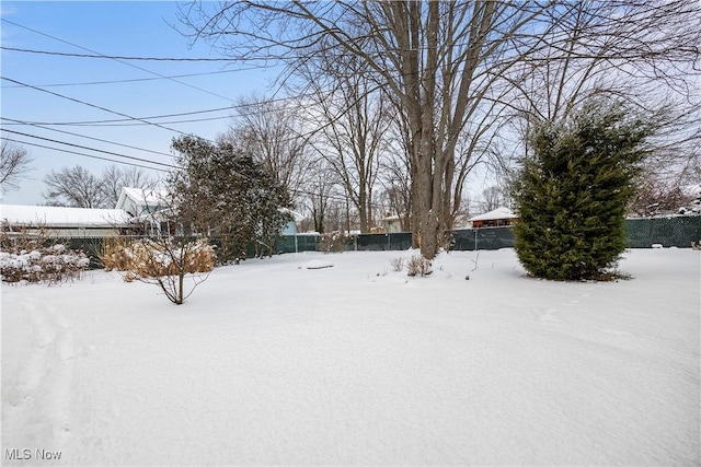 yard layered in snow with fence