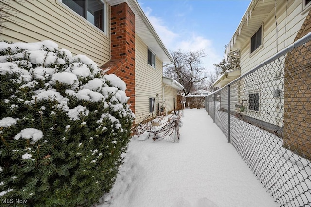 yard covered in snow featuring fence