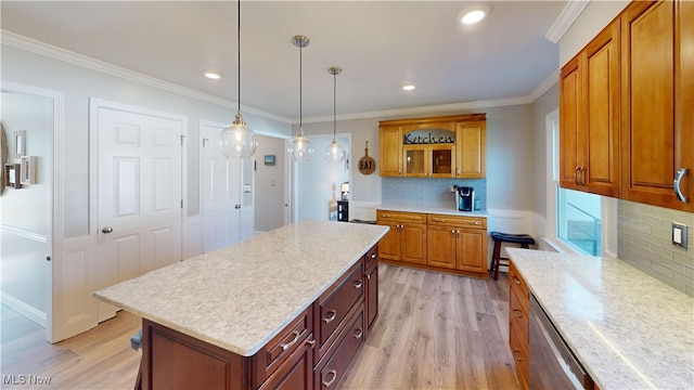 kitchen featuring light wood-type flooring, stainless steel dishwasher, crown molding, and light countertops