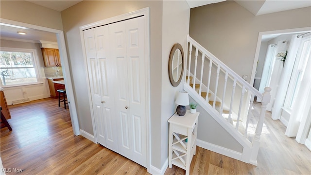 stairway featuring visible vents, baseboards, and wood finished floors