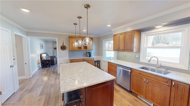 kitchen with light wood finished floors, backsplash, ornamental molding, stainless steel dishwasher, and a sink