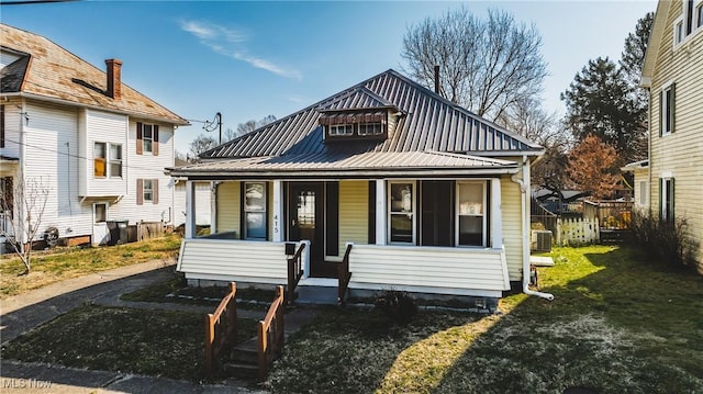 view of front of house featuring a porch, central AC, and metal roof