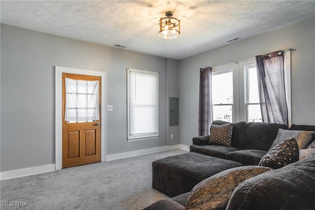 living room with baseboards, carpet, visible vents, and a textured ceiling