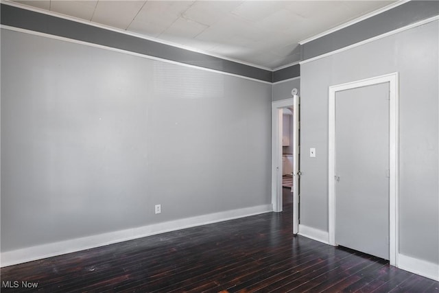 interior space featuring dark wood finished floors, baseboards, and ornamental molding