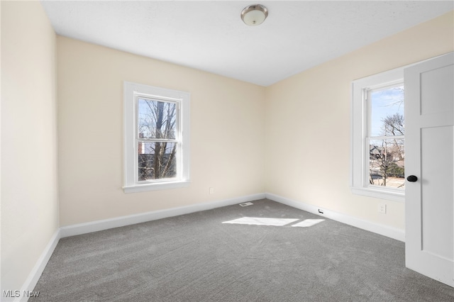 carpeted empty room with baseboards