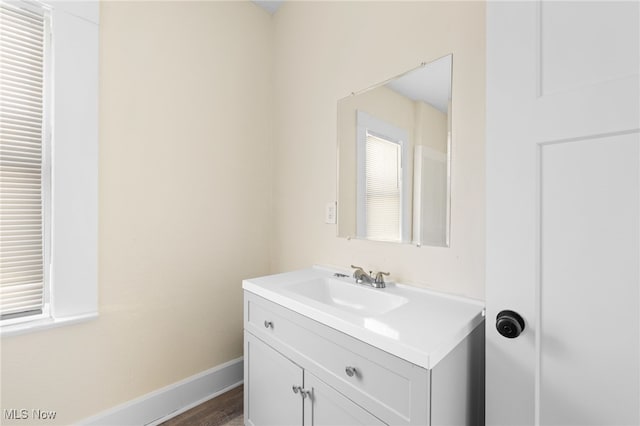 bathroom featuring baseboards, wood finished floors, and vanity