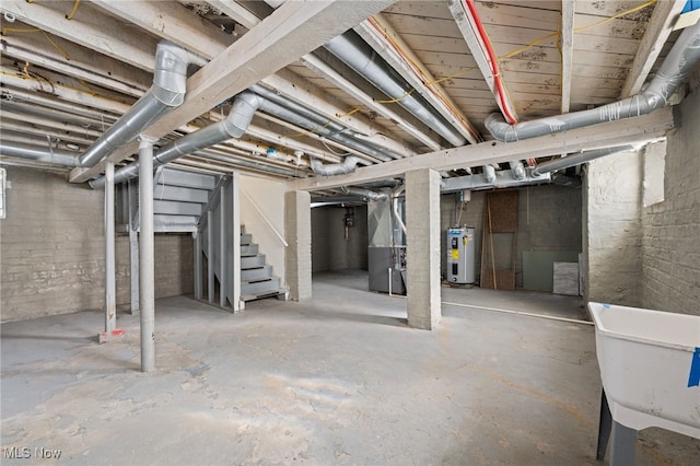 unfinished below grade area with heating unit, stairway, and electric water heater