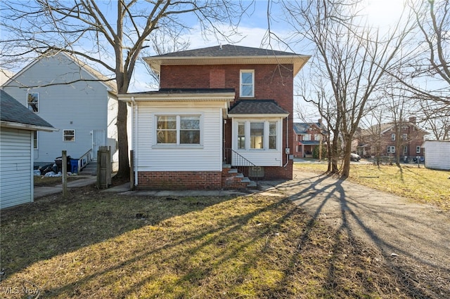 back of property with entry steps, a yard, and brick siding