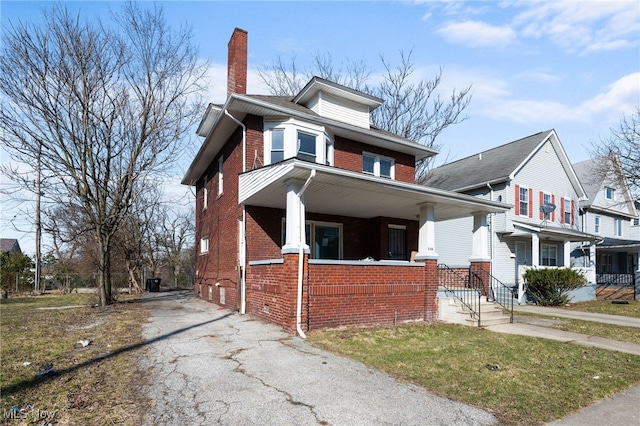 american foursquare style home with crawl space, brick siding, a porch, and a chimney