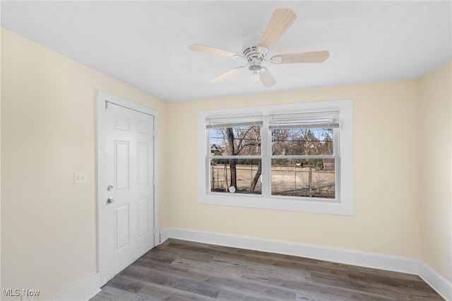 spare room with ceiling fan, baseboards, and wood finished floors