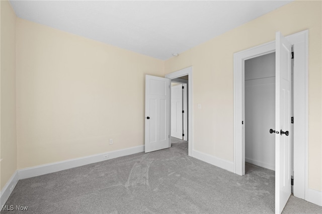 unfurnished bedroom featuring a closet, baseboards, and carpet flooring