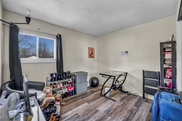 exercise area with dark wood-type flooring and a textured ceiling