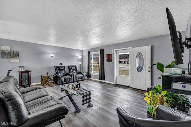 living area with wood finished floors, baseboards, and a textured ceiling