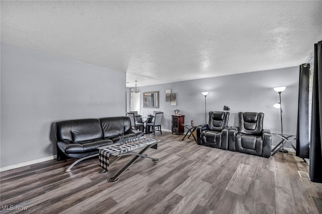 living area featuring baseboards, a textured ceiling, and wood finished floors