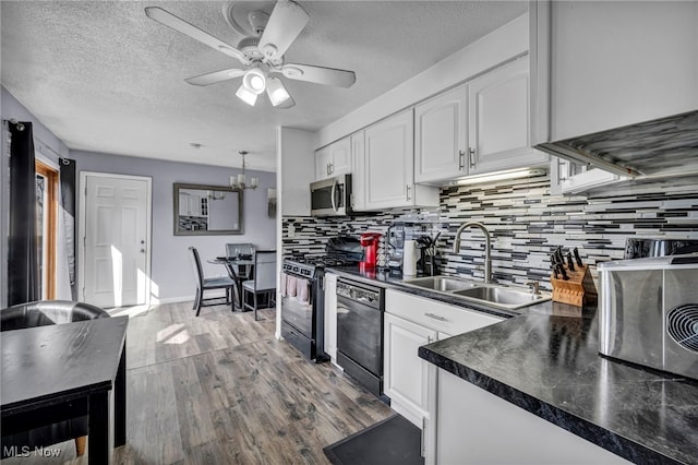 kitchen featuring white cabinetry, black appliances, dark countertops, and a sink