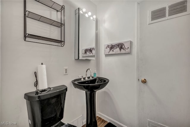 bathroom with visible vents and wood finished floors