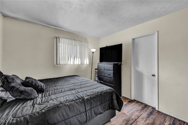 bedroom with wood finished floors and a textured ceiling