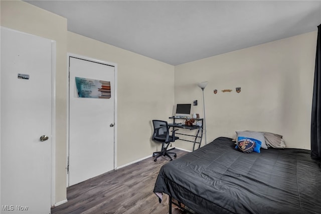 bedroom featuring baseboards and wood finished floors