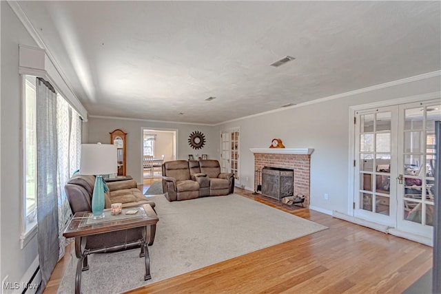 3164 Old Weymouth Rd, Medina, OH 44256 - living room with crown molding, french doors, a fireplace, light wood-style flooring, and visible vents
