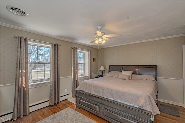 3164 Old Weymouth Rd, Medina, OH 44256 - bedroom with visible vents, crown molding, light wood finished floors, wallpapered walls, and a baseboard heating unit