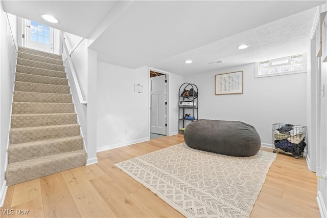 sitting room featuring recessed lighting, stairway, a healthy amount of sunlight, and light wood-type flooring