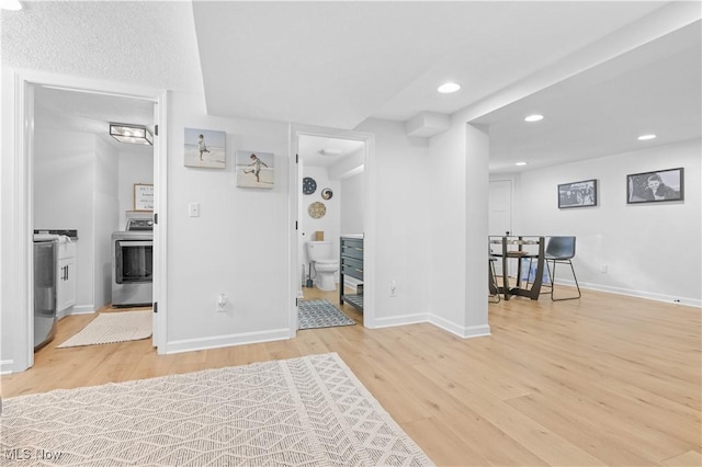 interior space featuring recessed lighting, ensuite bath, baseboards, and wood finished floors