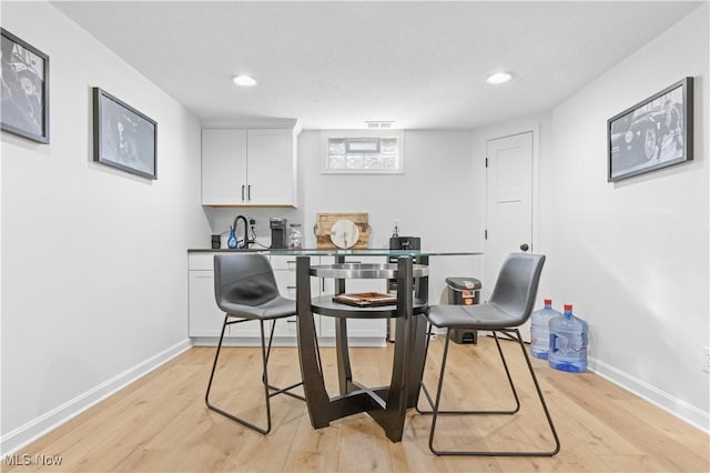 dining space with recessed lighting, baseboards, and light wood-type flooring