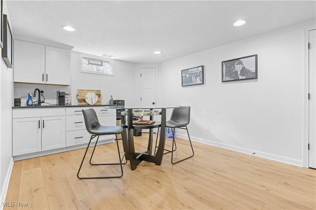 dining room featuring light wood-style flooring, recessed lighting, and baseboards