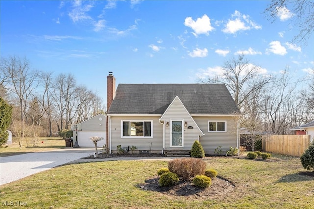 view of front facade featuring a garage, a chimney, a front lawn, and fence