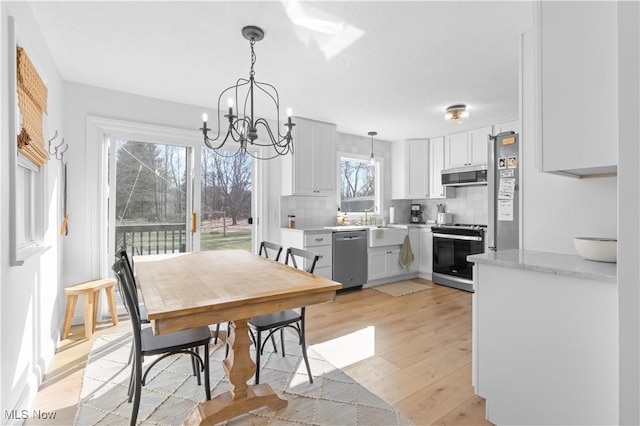 dining space with a notable chandelier and light wood-type flooring