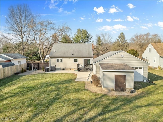 back of house with a yard, an outdoor structure, a shed, and a patio area