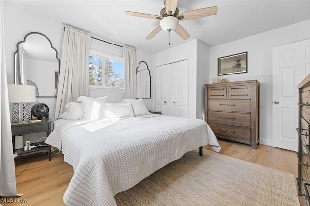 bedroom featuring light wood-style flooring, a ceiling fan, and a closet