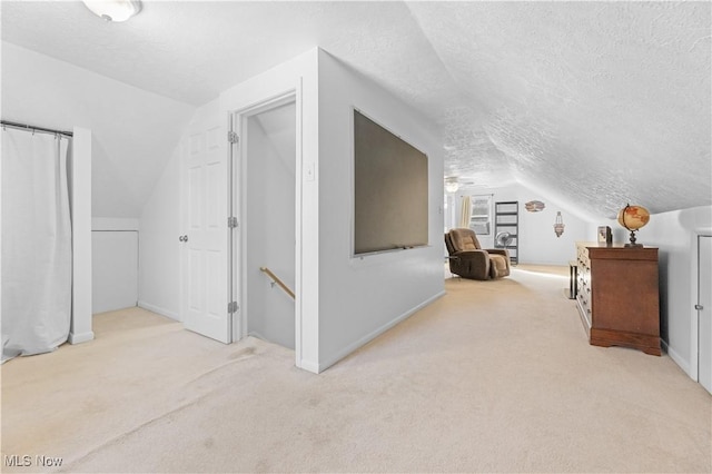 additional living space with vaulted ceiling, a textured ceiling, and carpet floors