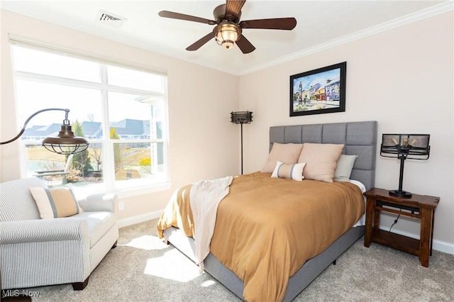 carpeted bedroom featuring visible vents, a ceiling fan, baseboards, and ornamental molding