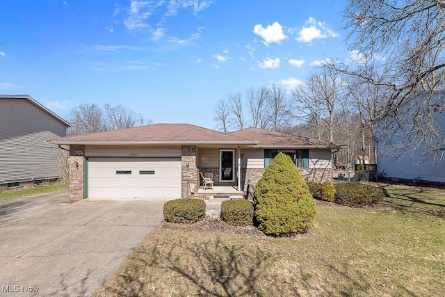 ranch-style house with concrete driveway, an attached garage, brick siding, and a front yard