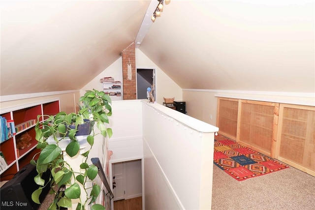 hall with lofted ceiling and carpet flooring