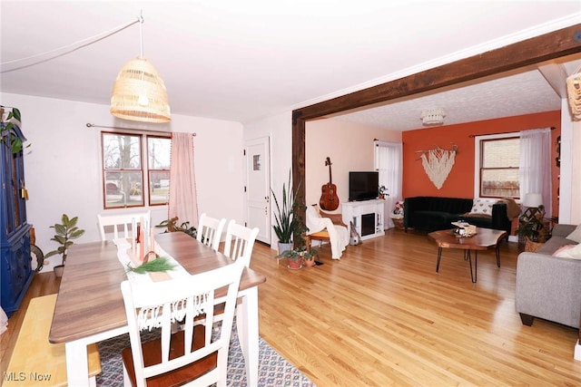 dining room featuring light wood-style floors and a fireplace