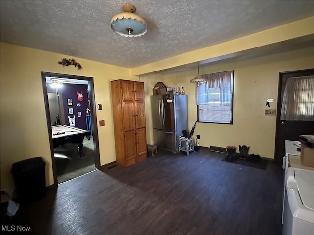 interior space featuring dark wood finished floors, baseboards, freestanding refrigerator, and a textured ceiling