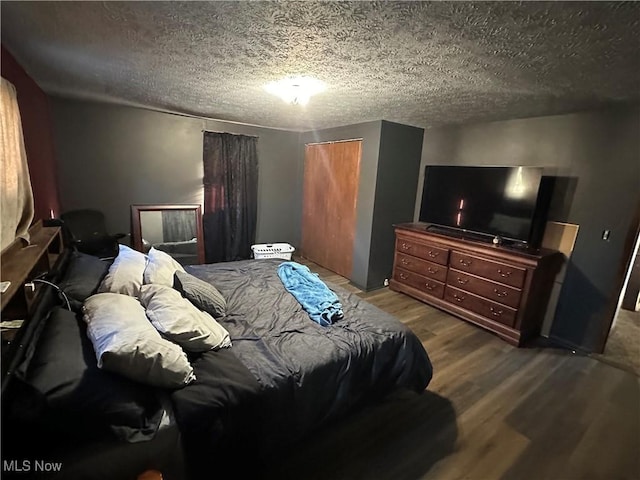 bedroom with wood finished floors, a closet, and a textured ceiling