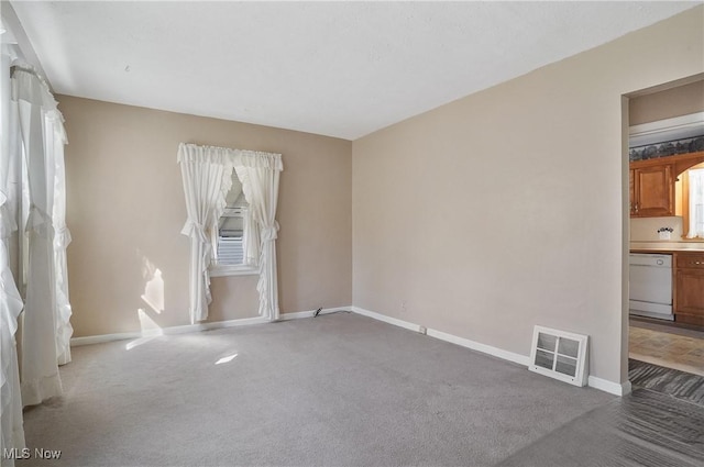 carpeted empty room with visible vents and baseboards