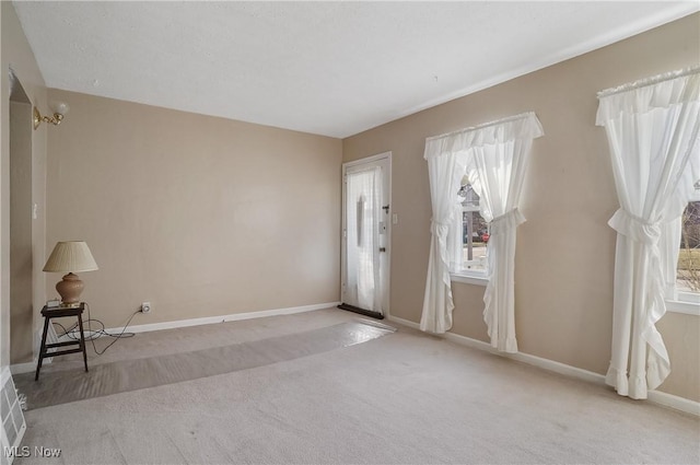 carpeted entryway featuring baseboards