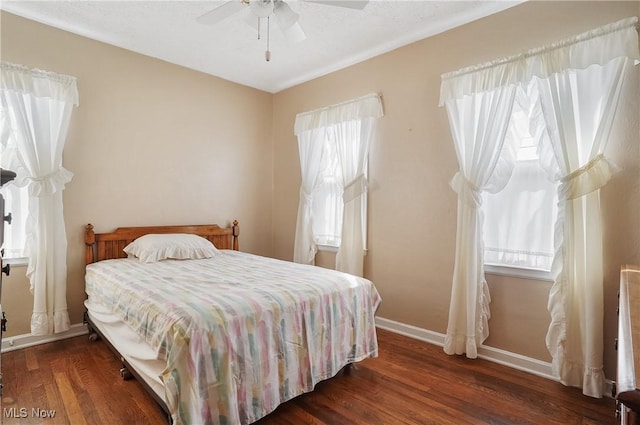 bedroom featuring ceiling fan, baseboards, and wood finished floors