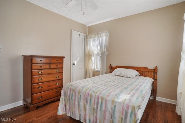 bedroom featuring dark wood-type flooring, a ceiling fan, baseboards, and a textured ceiling