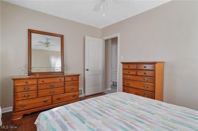 bedroom with ceiling fan, visible vents, baseboards, and dark wood-style floors