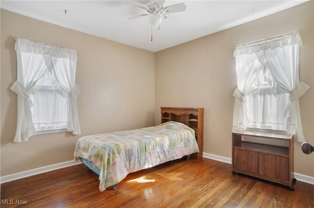 bedroom with ceiling fan, baseboards, and wood finished floors