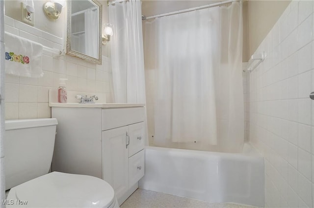 full bathroom featuring vanity, shower / bath combination with curtain, toilet, and tile walls