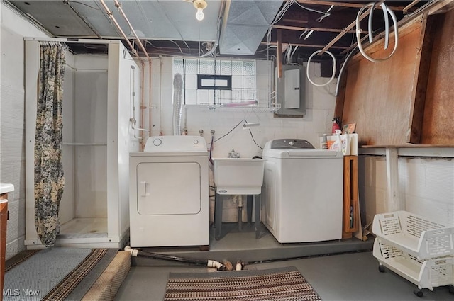 laundry room with electric panel, laundry area, washer and dryer, and a sink