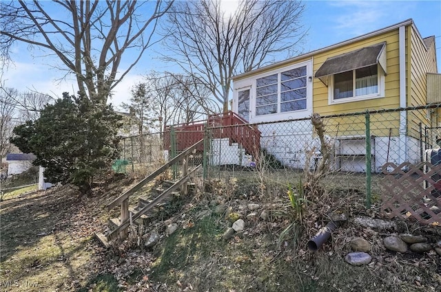 view of side of home featuring stairs and fence