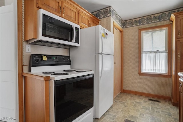 kitchen featuring baseboards, white appliances, brown cabinets, and wallpapered walls