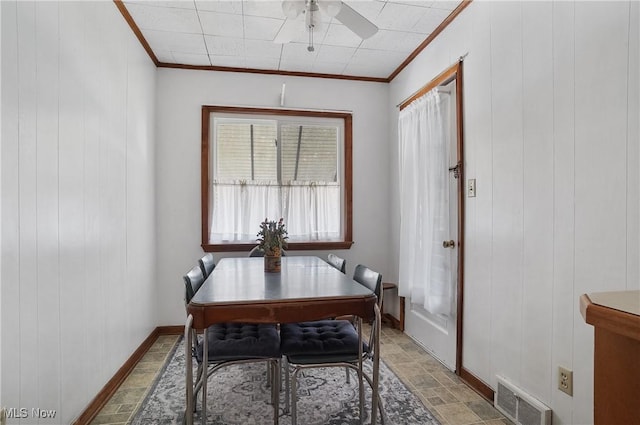 dining area with a ceiling fan, baseboards, visible vents, stone finish flooring, and crown molding